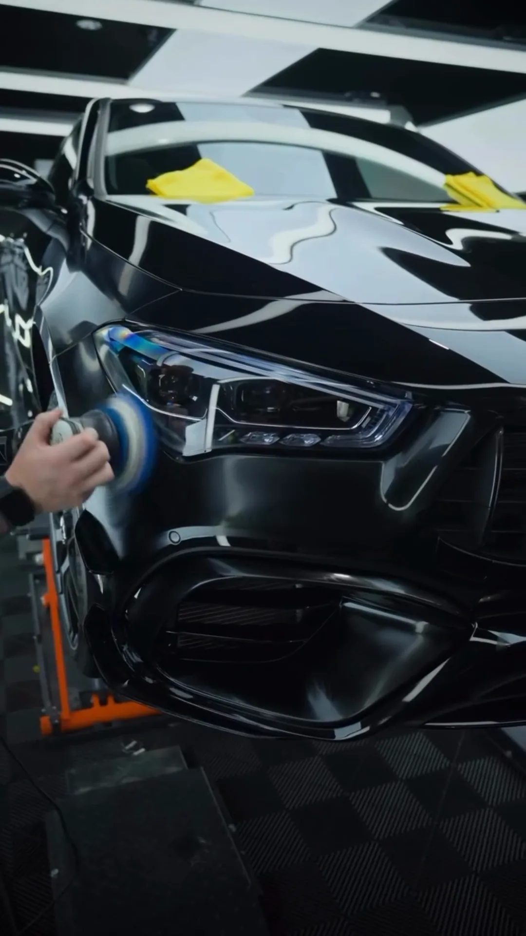 Polishing around the headlight of a black Mercedes-AMG