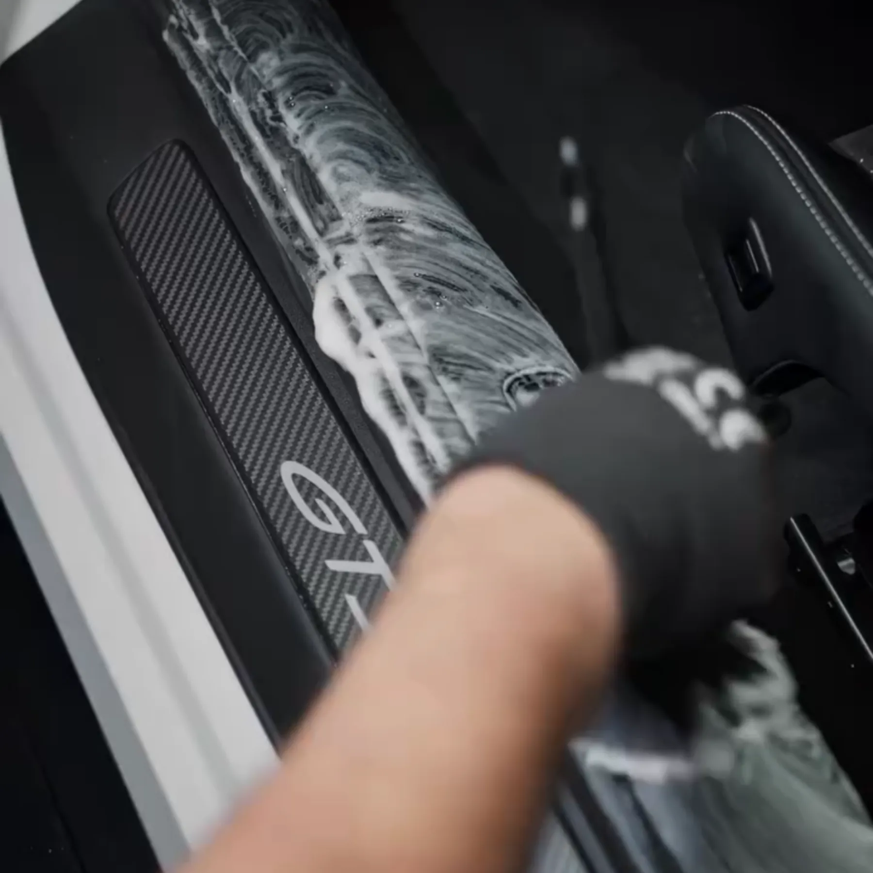 Gloved hand foaming and brushing a door sill
