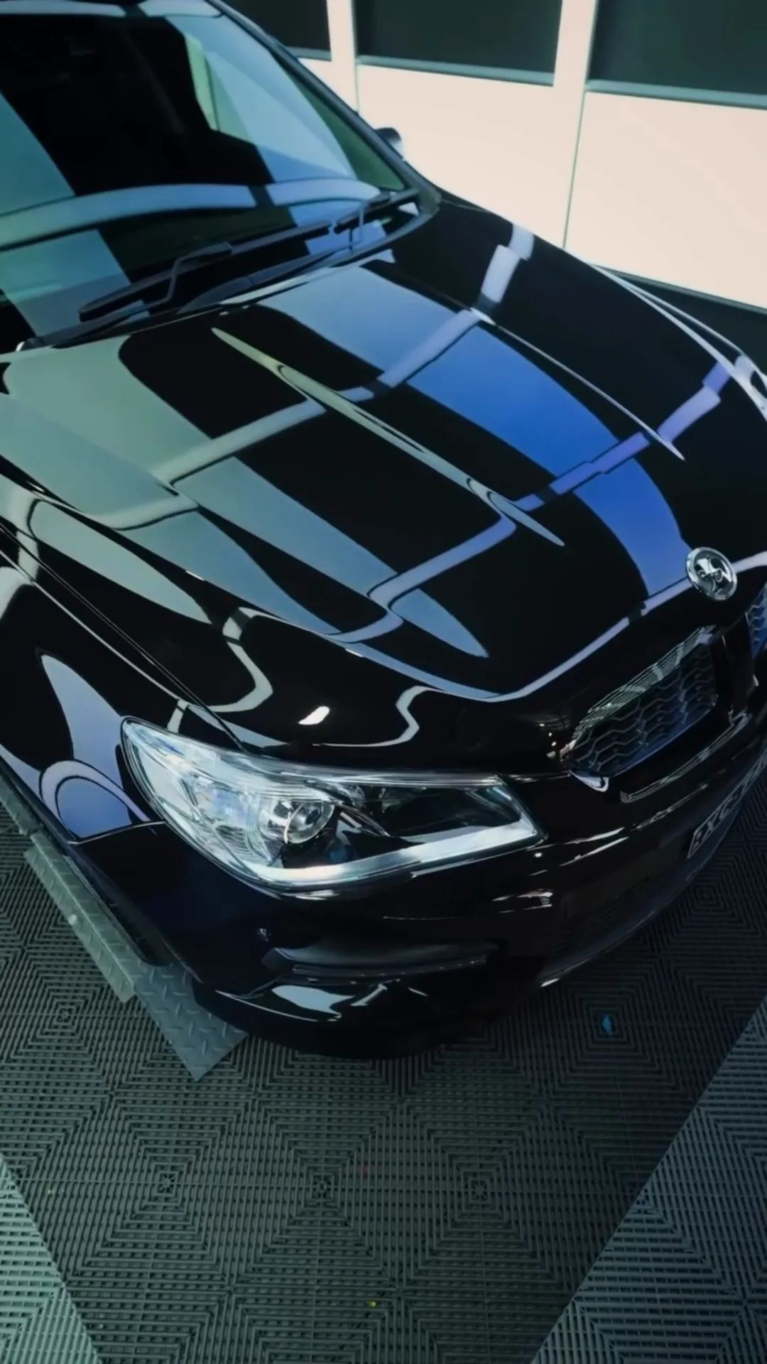 Black sedan bonnet with deep, clear reflections after correction